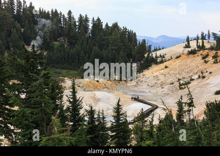 Distant view of winding boardwalk that helps hikers navigate the dangerous boiling springs and mudpots in Lassen Volcanic National Park Stock Photo