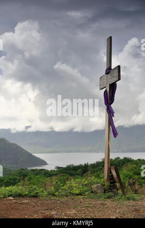 Purple clothed wooden cross-one of fourteen stations on the Via Crucis along Naang Kastila-Volcano Trail leading up to Crater Lake atop Volcano Island Stock Photo