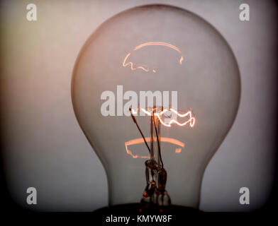 Old bulb lit with low power, concept saving energy Stock Photo