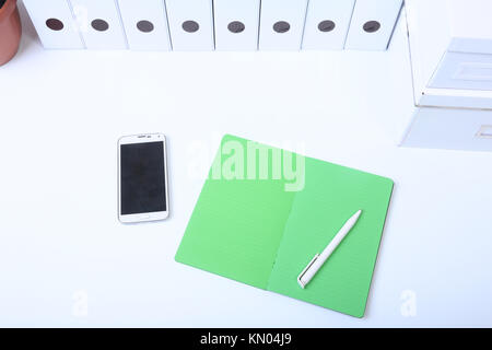 File folder with documents and important document with phone and notebook on isolated background Stock Photo