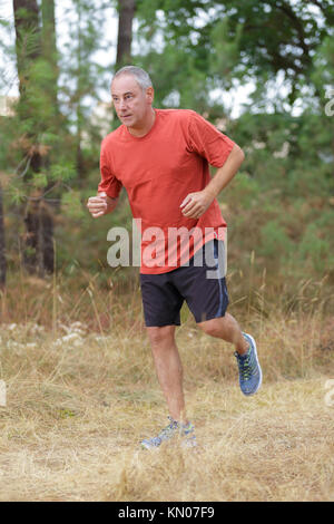middle aged man jogging in park Stock Photo