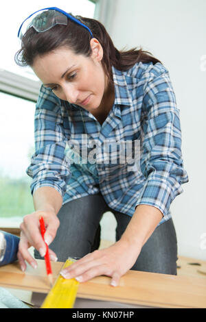 woman measuring a board for cutting Stock Photo