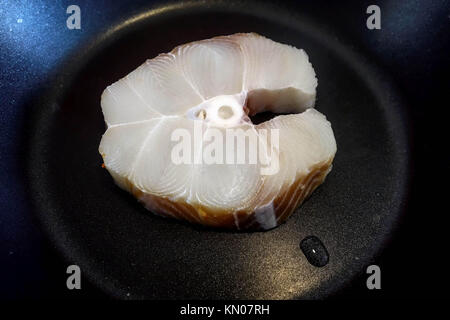 Blue Shark Fillet in a Frying Pan ready to be be cooked with Oil and Butter Stock Photo