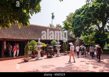 Tran Quoc Buddhist Temple buildings with people and tourists walking around the small courtyard, Hanoi, Vietnam Stock Photo