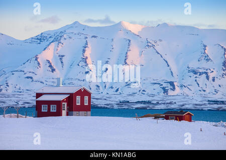 Iceland winter landscape with solitary living house positioned  of the fjord  at dawn (near Akureyri), northern Iceland. Stock Photo