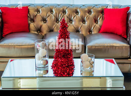 Holiday Party couch and mirror coffee table in red and white themed decor Stock Photo