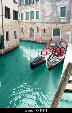 Beautiful foreshortening of buildings on a small canal in Venice, with detail of two gondola Stock Photo