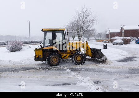 Local contractor attempting to clear the heavy snow fall on a housing estate in Chirk North East Wales Stock Photo