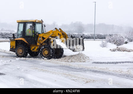 Local contractor attempting to clear the heavy snow fall on a housing estate in Chirk North East Wales Stock Photo