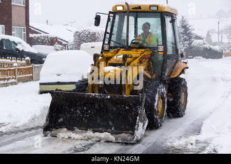 Local contractor attempting to clear the heavy snow fall on a housing estate in Chirk North East Wales Stock Photo