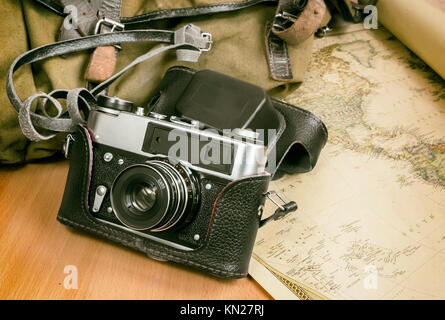 Items needed for travel: a large backpack, camera, map of the world. Vintage items in retro style. Stock Photo