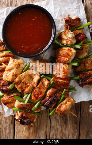 Chicken kebabs with green onions in a spicy sauce - Dakkochi close-up on the table. Vertical top view from above Stock Photo