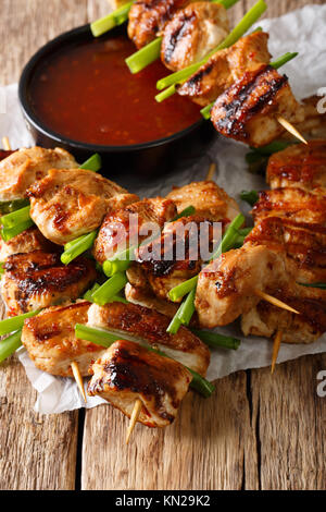 Korean chicken kebab with green onions and chilli sauce close-up on the table. vertical Stock Photo