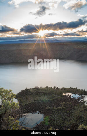 Clouds part to let sunset make a sun star over the water of the Cove Palisades near Culver, Oregon Stock Photo