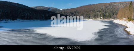Panorama of frozen Lauch Lake in winter on a sunny day, Vosges, France. Stock Photo