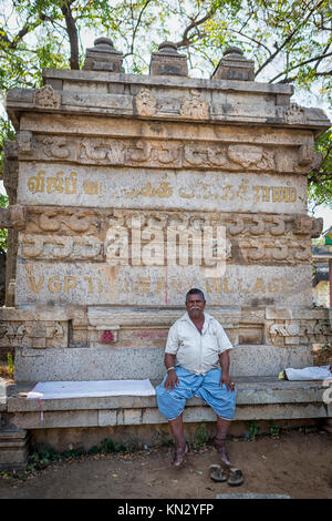 Portrait of an Indian man sits in front of a ruined statue posing for the picture Stock Photo