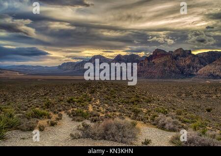 A storm forms in the sky as the sun sets over the rock formations at the Red Rock Canyon National Conservation Area February 19, 2013 near Las Vegas, Nevada.  (photo by Adam Loehnert via Planetpix) Stock Photo