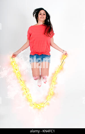 Digitally enhanced image of a female teen Skips Rope with a flaming rope Stock Photo