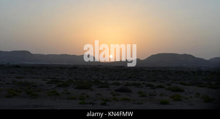 Sunset setting acorss the vast desert on Central Oman Stock Photo