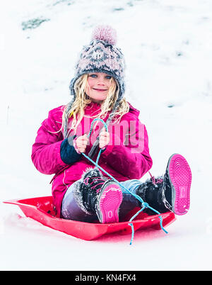 Ellie Spencer sledging near Mam Tor in the, Peak District National Park, as heavy snowfall across parts of the UK is causing widespread disruption, closing roads and grounding flights at an airport. Stock Photo