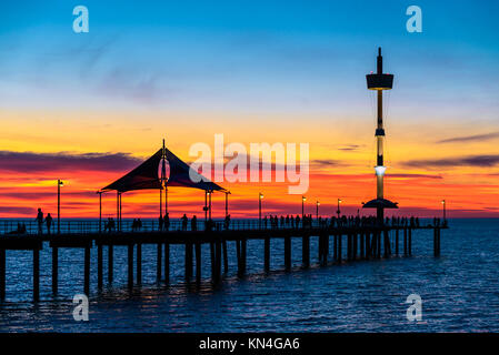 People walking along Brighton Jetty at sunset. South Australia Stock Photo