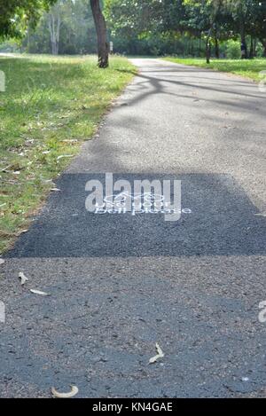 Use your bell please spray painted message on path running along Ross River, Townsville, Queensland, Australia Stock Photo