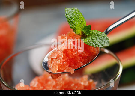 Natural dessert, granite from ripe watermelon and lime in a spoon with mint leaves, close-up Stock Photo