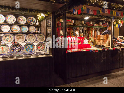 Two stalls, one selling colourful plates, one selling gifts and accessories from Tibet, in the Christmas Market in Princes Street, Edinburgh, 2017 Stock Photo