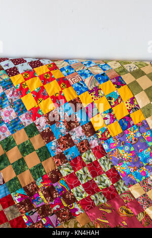 retro, fashion, housekeeping concept. bedcover made in quilt style gently stiched from different peaces of textile has yellow, blue, green color zones Stock Photo