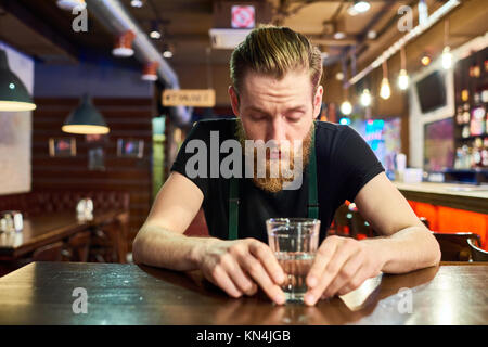 Young Bearded Man Getting Drunk in Bar Stock Photo