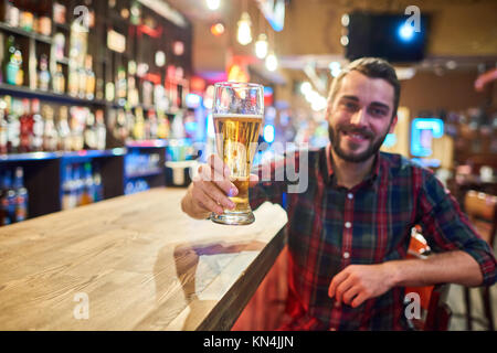 Happy Young Man Cheering at Bar Counter Stock Photo