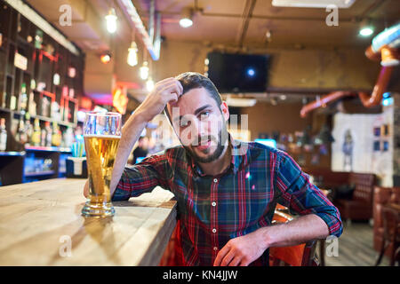 Young Man Sitting at Bar Counter Stock Photo