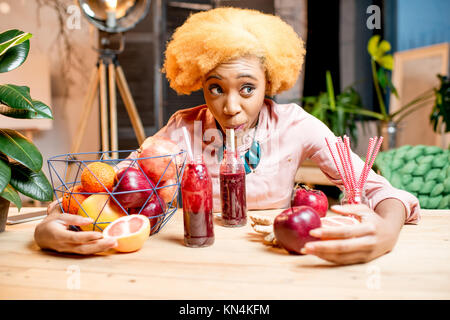 Woman with fruits and smoothies at home Stock Photo