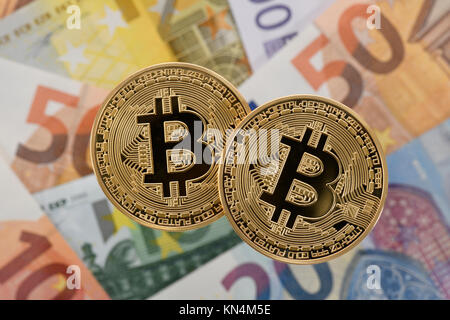 Symbol image cryptocurrency, digital currency, golden physical coin Bitcoin on EURO banknotes Stock Photo