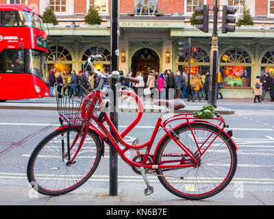 A smart red bicycle parked on Piccadilly outside Fortnum & Masons Stock Photo