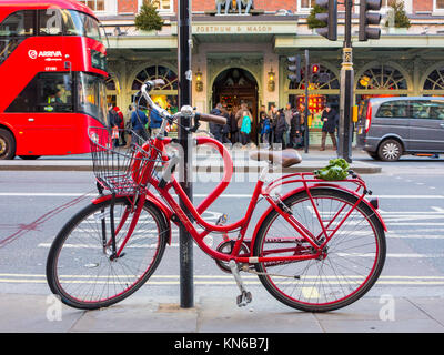 A smart red bicycle parked on Piccadilly outside Fortnum & Masons Stock Photo
