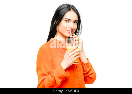 Cheerful woman in shirt and straw hat drinks freshly squeezed orange juice, white background. Young girl with yellow vitamin beverage, healthy lifesty Stock Photo