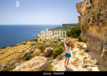 A young woman enjoys the Mediterranean landscape in Malta Stock Photo