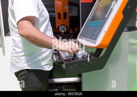 Man working at programmable CNC machine Stock Photo