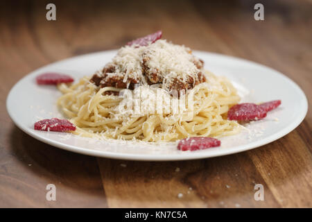 Add bolognese sauce on spaghetti in pot. cooking pasta bolognese at home  Stock Photo - Alamy