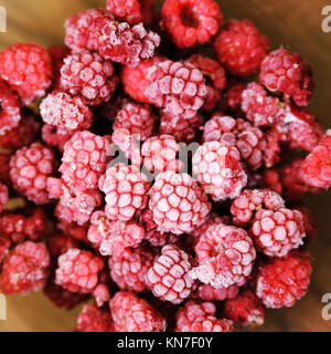 Frozen raspberries close up. Berries on a wooden background. Stock Photo