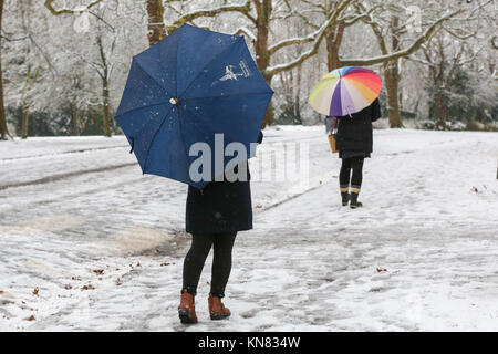 London. UK 10 Dec 2017 - A woman with an Evening Standard umbrella in Finsbury Park, north London after the first snowfalls of the winter. According to the Met Office the snow in London is the largest amount of snowfall since March 2013. Stock Photo
