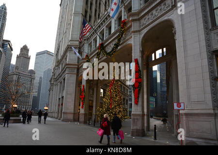 Chicago, USA. 10th Dec, 2017. Holiday shoppers on Michigan Avenue's 'Magnificent Mile' walk past the Christmas lights on the Wrigley Building on a brisk evening in Chicago. Credit: D Guest Smith/Alamy Live News Stock Photo