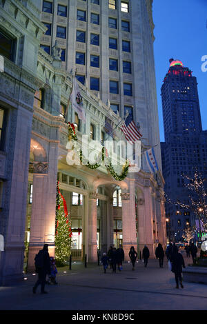 Chicago, USA. 10th Dec, 2017. Holiday shoppers on Michigan Avenue's 'Magnificent Mile' walk past the Christmas lights on the Wrigley Building on a brisk evening in Chicago. Credit: D Guest Smith/Alamy Live News Stock Photo