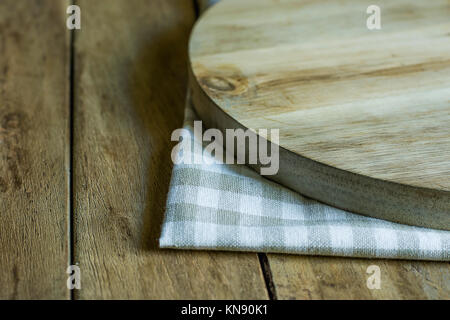 Hand Crafted Round Wood Cutting Board on Folded Cotton Checkered Kitchen Towel Plank Table Natural Light Rustic Style Copy Space Stock Photo