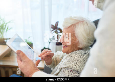 Laughing Elderly Lady Using Tablet Stock Photo