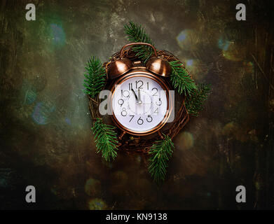 Vintage Copper Alarm Clock Five Minutes to Midnight New Years Countdown Christmas Wreath Fir Tree Branches on Black Background Glittering Lights Greet Stock Photo