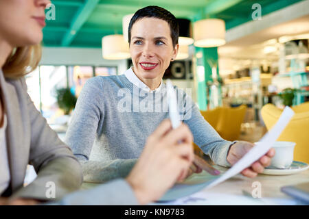 Mature Business Woman Leading meeting in Cafe Stock Photo