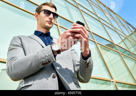 Handsome Businessman Using Smartphone Outdoors Stock Photo