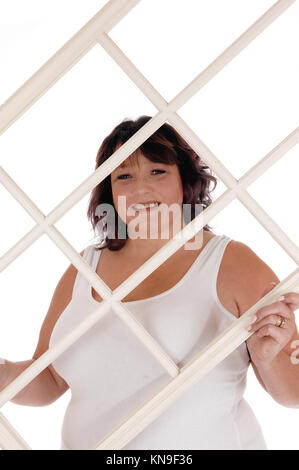 An oversized woman in her forties standing in a white t-shirt  holding up an window frame, isolated for white background Stock Photo